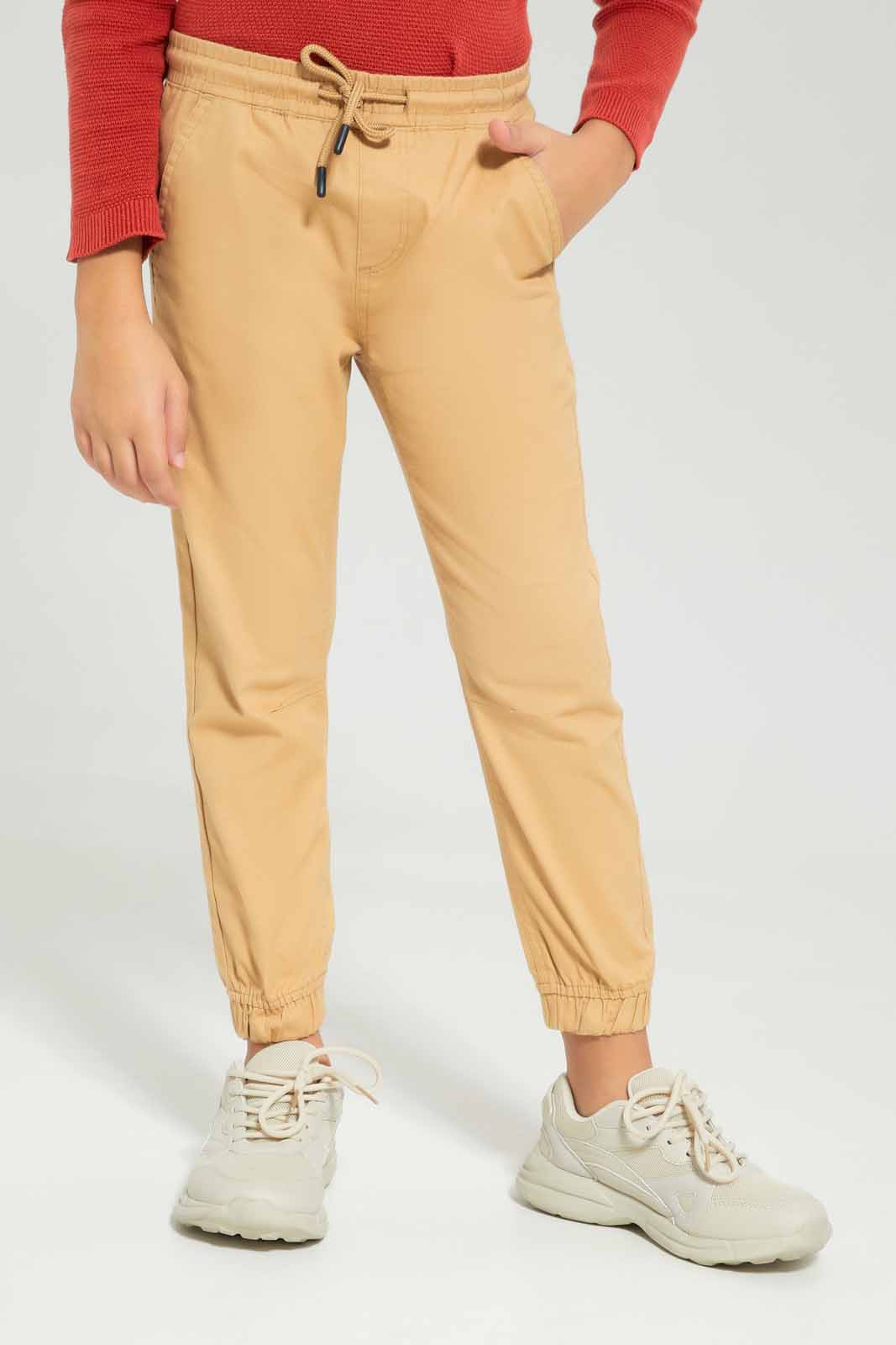 Redtag-Boys-Beige-Elasticated-Waist-Jogger-BOY-Trousers,-Category:Trousers,-Colour:Beige,-Deals:New-In,-Dept:Boys,-Filter:Boys-(2-to-8-Yrs),-New-In-BOY-APL,-Non-Sale,-S23A,-Section:Boys-(0-to-14Yrs),-VLM-Boys-2 to 8 Years
