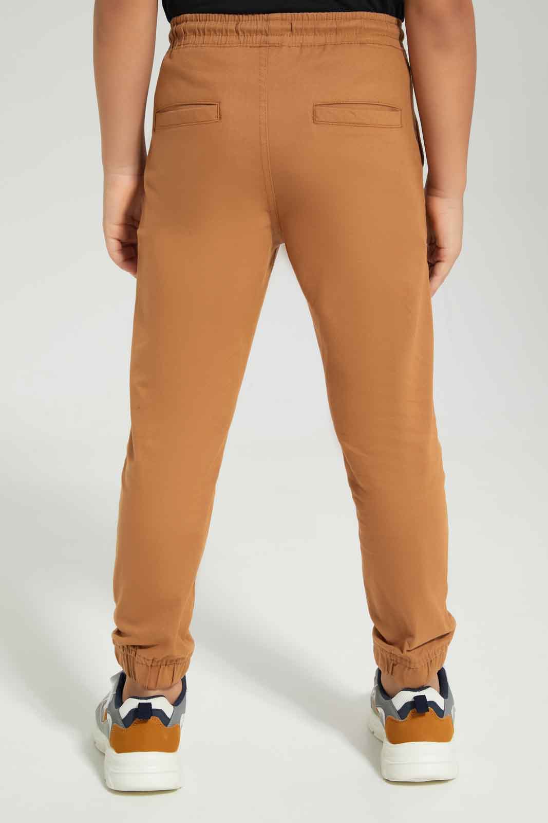 Redtag-Boys-Brown-Elasticated-Waist-Jogger-BOY-Trousers,-Category:Trousers,-Colour:Brown,-Deals:New-In,-Dept:Boys,-Filter:Boys-(2-to-8-Yrs),-New-In-BOY-APL,-Non-Sale,-S23A,-Section:Boys-(0-to-14Yrs),-VLM-Boys-2 to 8 Years