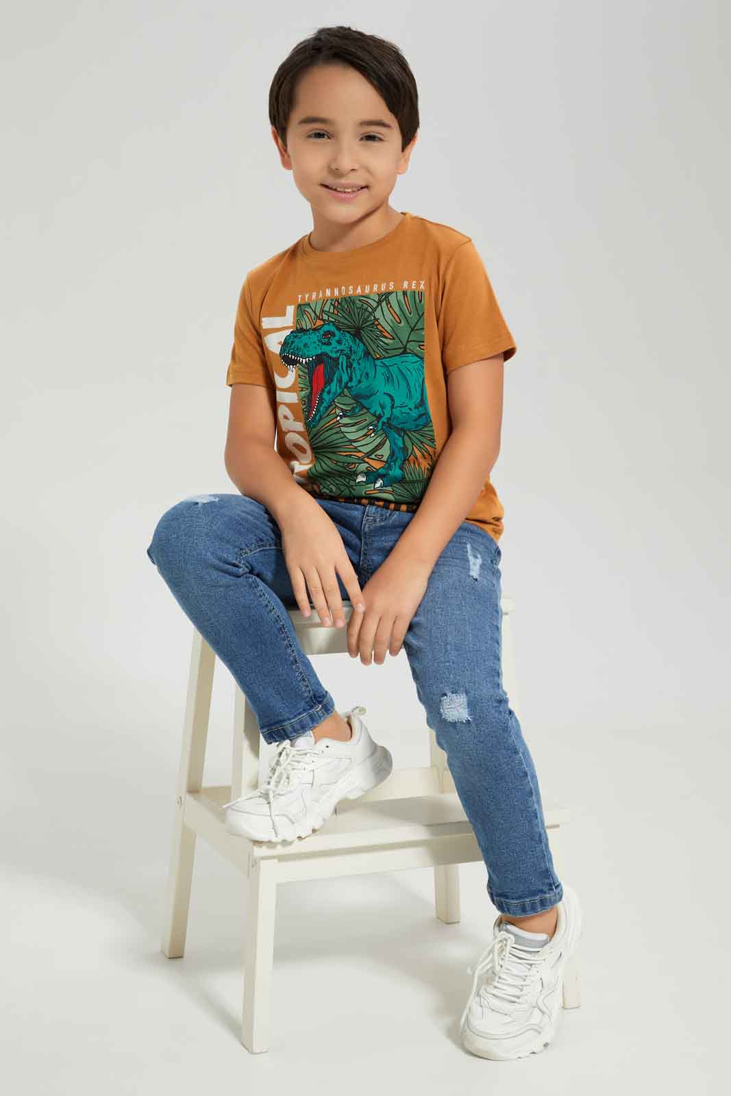 Redtag-Boys-Brown-Dino-Short-Sleeve-Graphic-T-Shirt-BOY-T-Shirts,-Category:T-Shirts,-Colour:Brown,-Deals:New-In,-Dept:Boys,-Filter:Boys-(2-to-8-Yrs),-New-In-BOY-APL,-Non-Sale,-S23A,-Section:Boys-(0-to-14Yrs),-TBL-Boys-2 to 8 Years